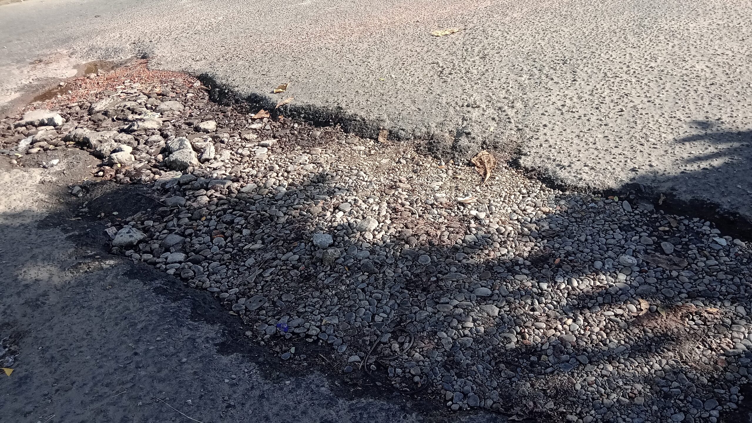 Conductores y vecinos rellenan zanjascon piedras para movilidad en arterias viales